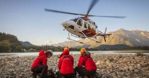 Helicóptero de rescate en acción sobre una zona montañosa, destacando el papel crítico de los pilotos en situaciones de emergencia.