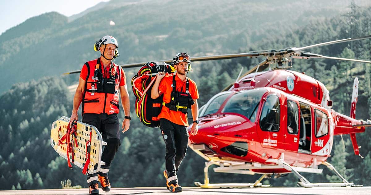 Rescue helicopter in action over a mountainous area, highlighting the critical role of pilots in emergency situations.